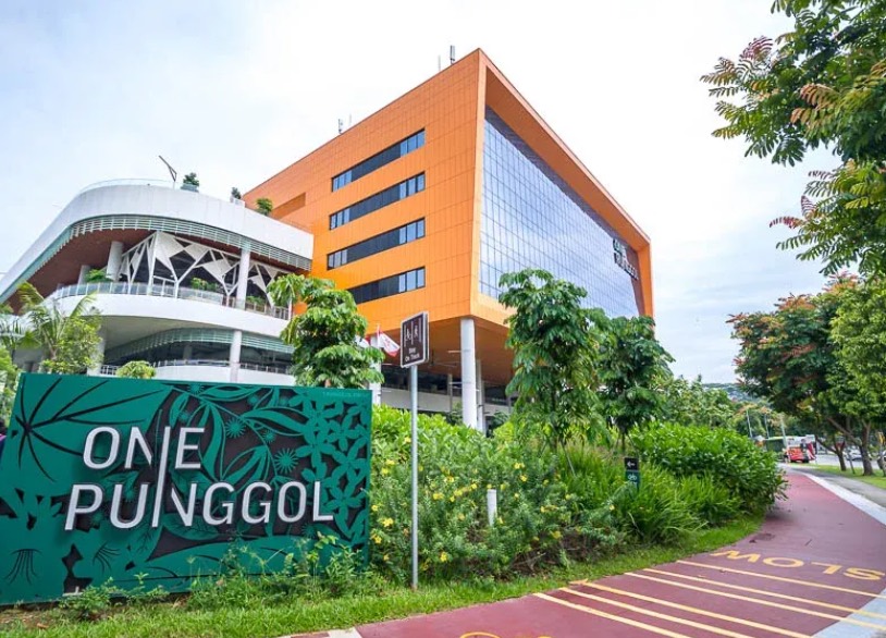 One Punggol, the Finale Event venue: an orange and glass community building beside the Punggol Waterway park connector, with the One Punggol sign in the foreground.